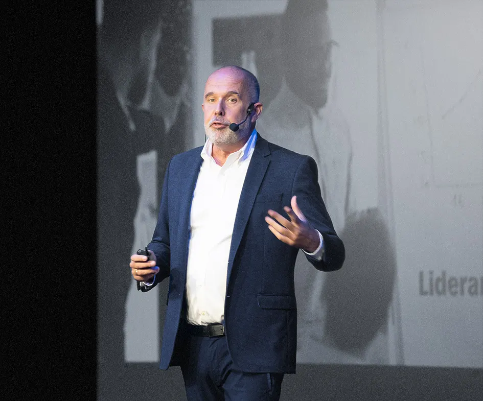 Marcelo Caetano de microfone headset, gesticulando durante uma palestra